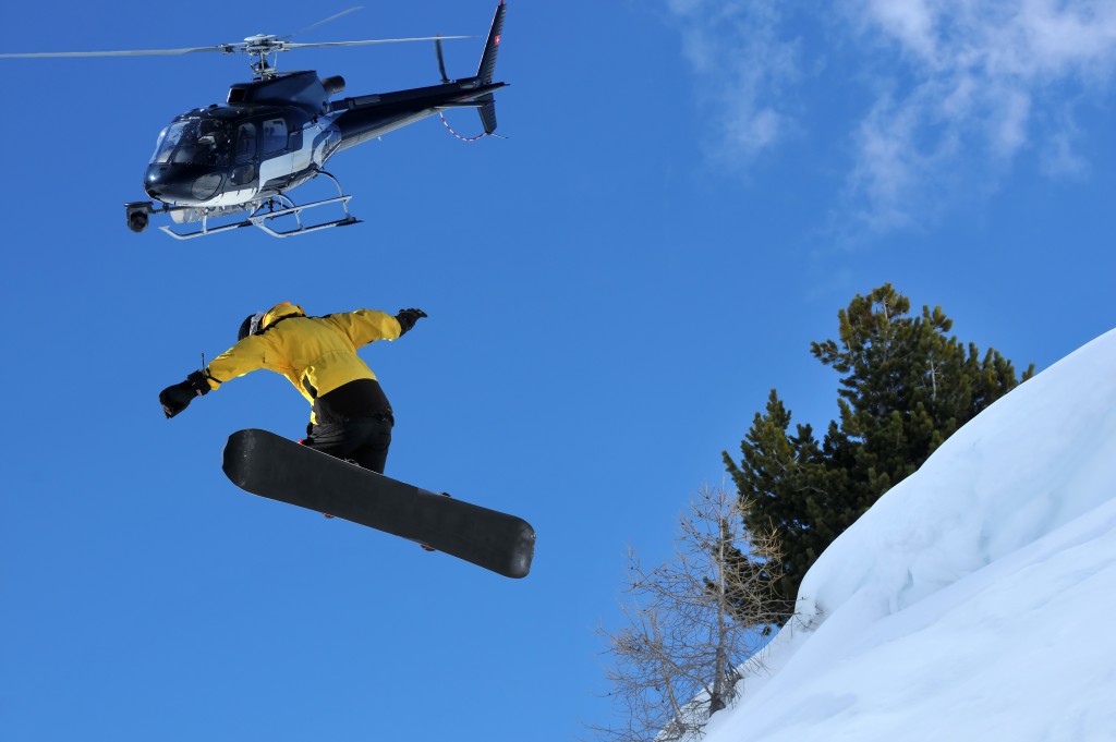 Snowboarder jumping off a ridge