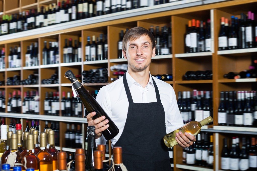 Vendor holding wine at the shop