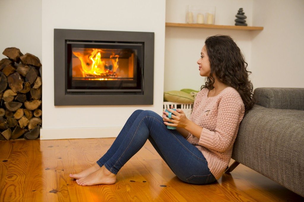 woman enjoying her drink by the fireplace