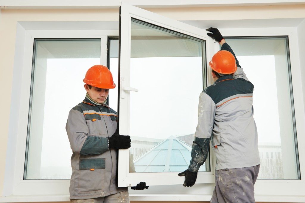 Two male builders workers at window installation