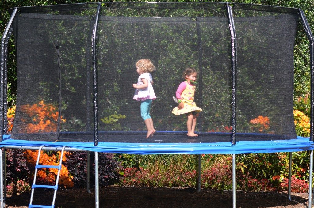 Kids jumping on the backyard trampoline