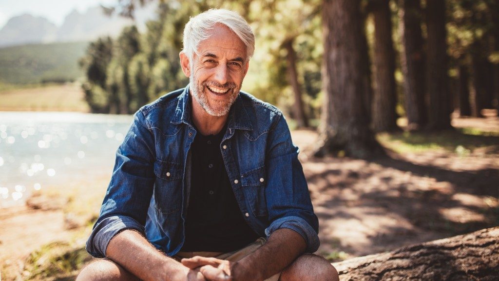 man sitting outdoors by the lake