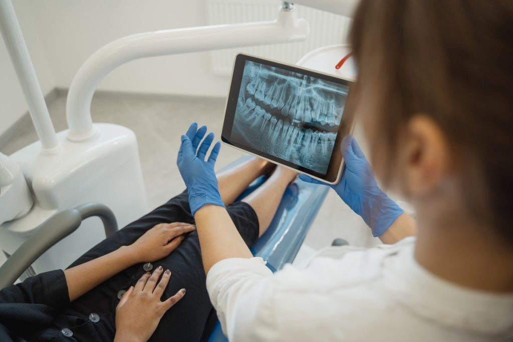 dentist showing x-ray of teeth to patient