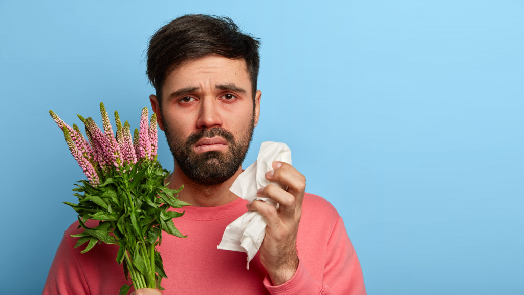 man holding flowers that he's allergic to