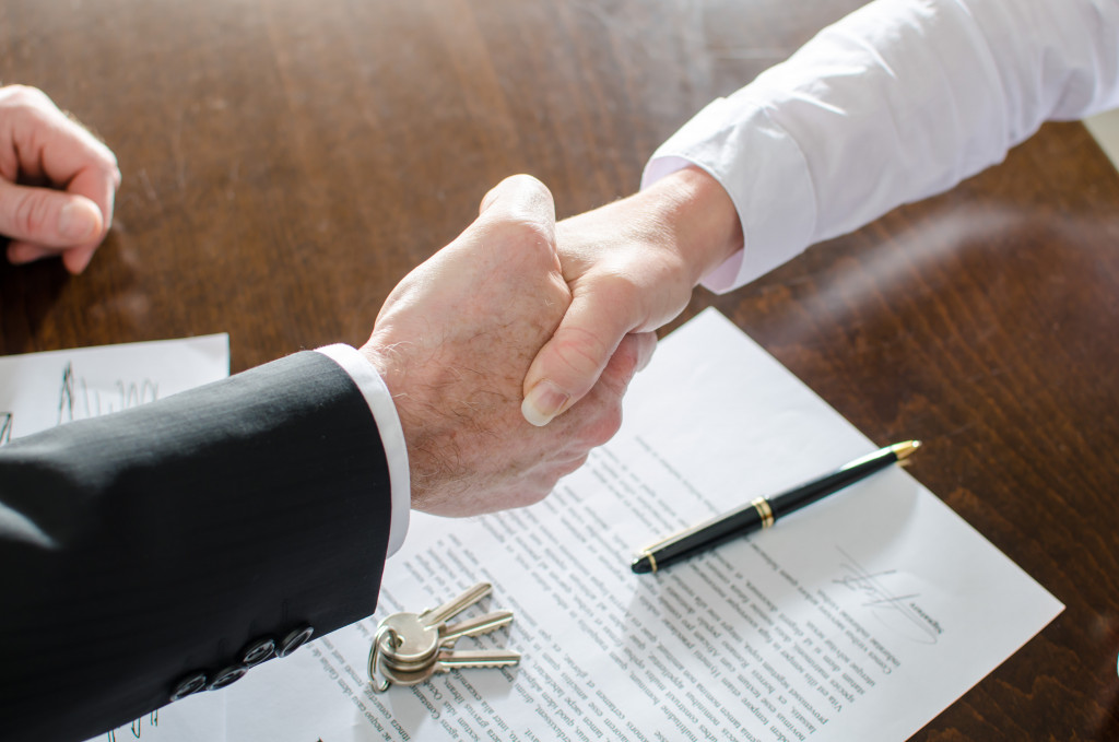 an estate agent shaking hands with client buying property