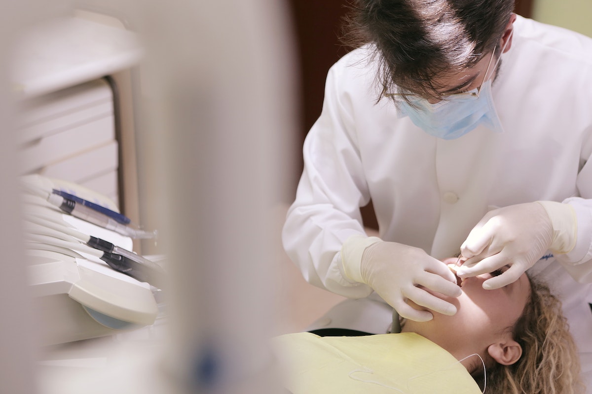 Male Dentist Working on Woman's Teeth