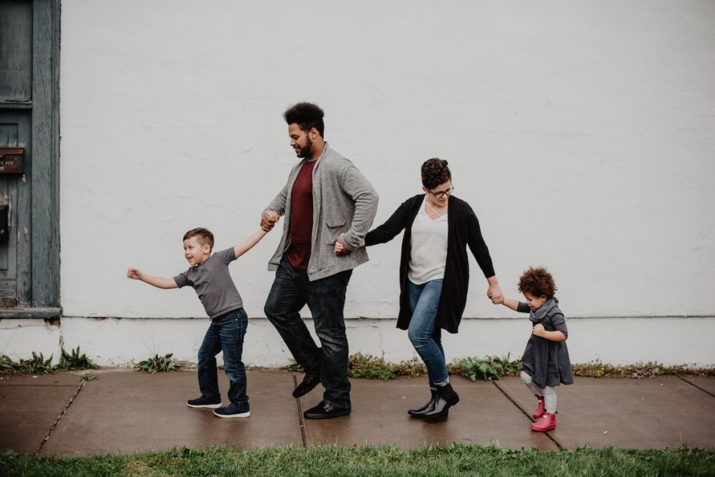 Family Of Four Walking At The Street